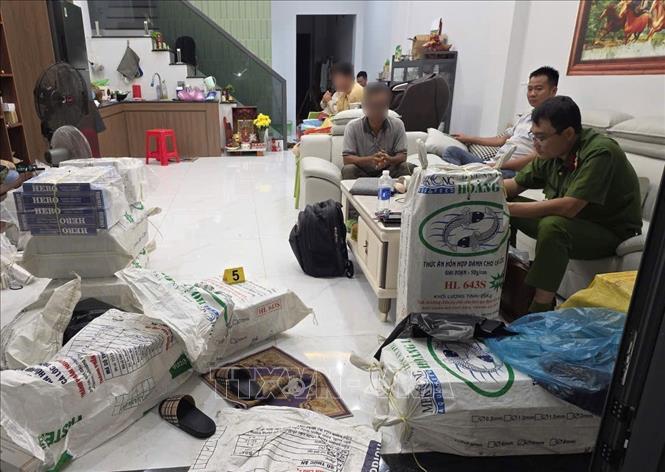 Lực lượng chức năng kiểm tra, phát hiện số lượng lớn thuốc lá lậu được cất giấu trong nhà của Thanh, Châu. Ảnh: TTXVN phát