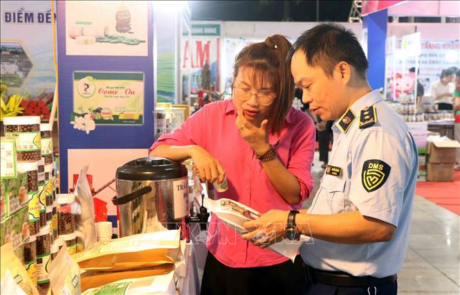 Cán bộ Sở Công thương Hà Tĩnh giới thiệu hàng giả, hàng thật để người tiêu dùng tìm hiểu. Ảnh: Công Tường-TTXVN 