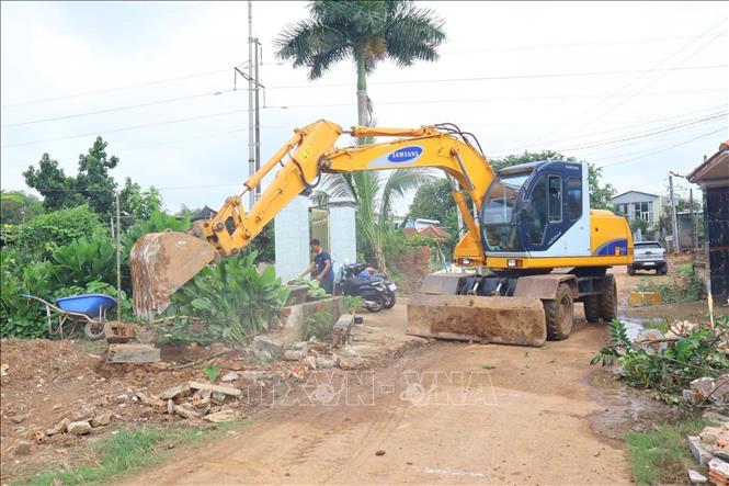 Người dân hiến đất và bàn giao mặt bằng dự án mở rộng các tuyến đường giao thông trên địa bàn phường Bình Phước. Ảnh: Nhật Bình – TTXVN. 