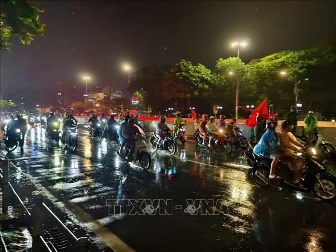 Cơn mưa xuyên suốt cả ngày không ngăn được niềm vui của người hâm mộ Thủ đô. Ảnh: Minh Quyết - TTXVN