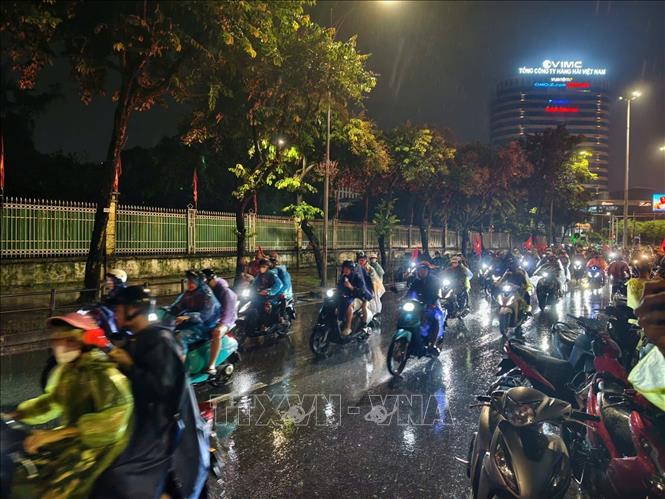 Cơn mưa xuyên suốt cả ngày không ngăn được niềm vui của người hâm mộ Thủ đô. Ảnh: Minh Quyết - TTXVN