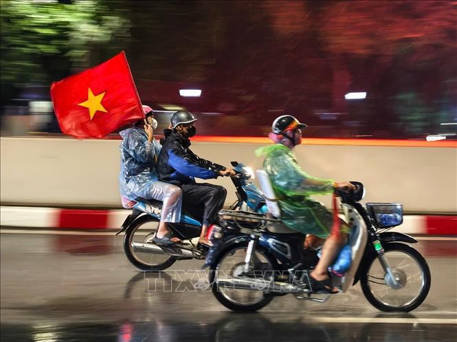 Niềm vui sau chiến thắng khiến người hâm mộ Thủ đô dù mưa vẫn ra đường chung vui cùng đội tuyển Việt Nam. Ảnh: Minh Quyết - TTXVN