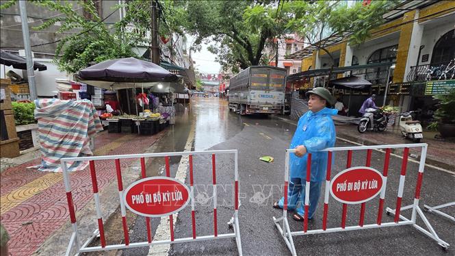 Lực lượng chức năng phường Kỳ Lừa, tỉnh Lạng Sơn lập rào chắn khu vực ngập úng. Ảnh: Quang Duy – TTXVN
