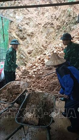 Bộ đội Biên phòng tỉnh Lạng Sơn giúp nhân dân hót dọn đất đá sạt lở vào nhà. Ảnh: TTXVN phát