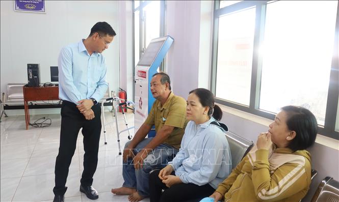 Bí thư Đảng ủy xã Đăk Nhau Nguyễn Trọng Lậm thăm hỏi, trao đổi với người dân tại Trung tâm Phục vụ hành chính công xã. Ảnh: Đậu Tất Thành – TTXVN.