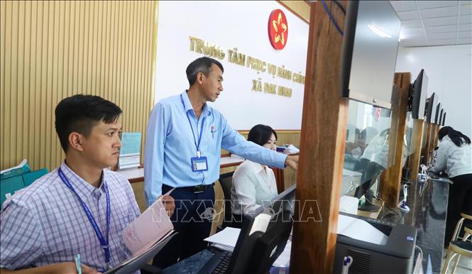 Ông Đào Văn Long (áo xanh), Phó Giám đốc phụ trách Trung tâm Phục vụ Hành chính công xã Đăk Nhau, cho biết sau khi địa bàn được sắp xếp, khối lượng hồ sơ cần tiếp nhận, giải quyết tăng lên. Ảnh: Đậu Tất Thành – TTXVN.
