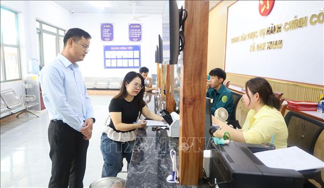 Có mặt tại Trung tâm để thực hiện thủ tục đăng ký giấy phép kinh doanh, chị Nguyễn Thị Minh (áo đen), ở thôn Thống Nhất, xã Đăk Nhau, đánh giá cán bộ tại đây hướng dẫn tận tình, tỉ mỉ, thái độ phục vụ vui vẻ. Ảnh: Đậu Tất Thành – TTXVN.