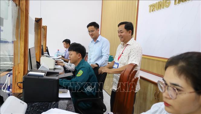 Lãnh đạo xã Đăk Nhau kiểm tra công tác tiếp nhận, giải quyết thủ tục hành chính tại Trung tâm Phục vụ hành chính công xã. Ảnh: Đậu Tất Thành – TTXVN.