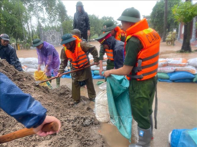 Lực lượng công an tỉnh Bắc Ninh hỗ trợ người dân chống lụt. Ảnh: Danh Lam - TTXVN