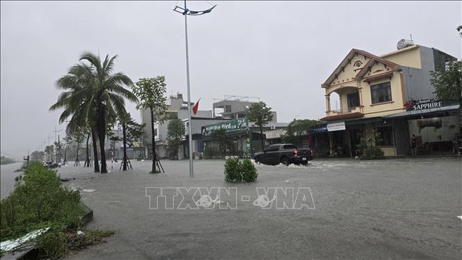 Nước biến thành sông, một số xe ô tô bị chết máy giữa đường. Ảnh: Thanh Vân - TTXVN