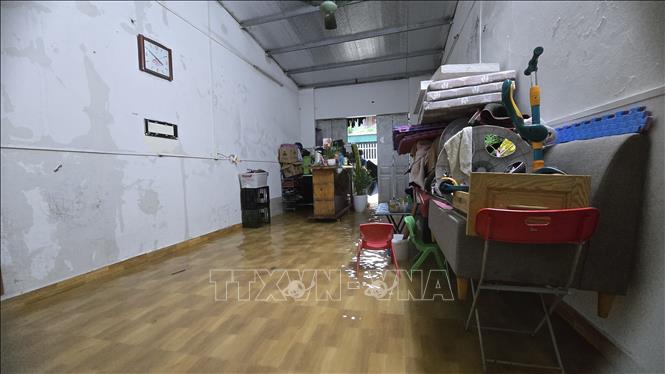 Nước ngập sâu vào nhà dân, ảnh hưởng đến sinh hoạt, kinh doanh. Ảnh: Thanh Vân - TTXVN