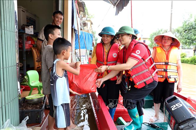 Bà Vũ Thị Quyên, Phó Chủ tịch Hội Chữ thập đỏ tỉnh Lạng Sơn trao quà cho trẻ em có nhà bị ngập tại xã Thất Khê, tỉnh Lạng Sơn. Ảnh: Văn Đạt - TTXVN