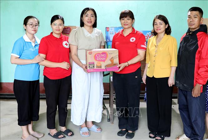 Lãnh đạo Ủy ban MTTQ Việt Nam tỉnh Lạng Sơn và Hội Chữ thập đỏ tỉnh Lạng Sơn trao quà cho lãnh đạo Hội Chữ thập đỏ xã Tràng Định để gửi tới các hộ dân vùng ngập sâu. Ảnh: Văn Đạt - TTXVN