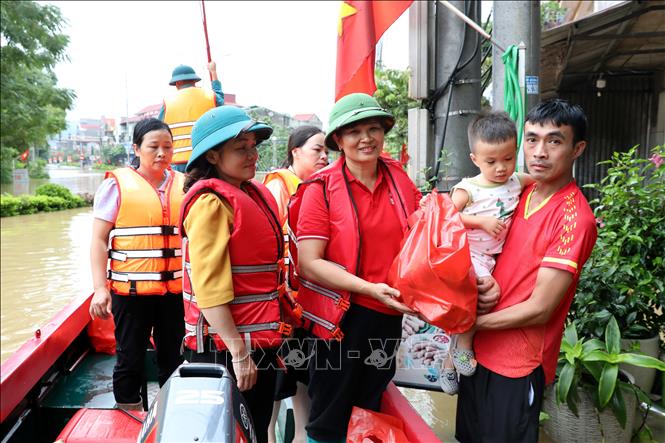 Bà Vũ Thị Quyên, Phó Chủ tịch Hội Chữ thập đỏ tỉnh Lạng Sơn trao quà cho hộ dân có nhà bị ngập tại xã Thất Khê, tỉnh Lạng Sơn. Ảnh: Văn Đạt - TTXVN