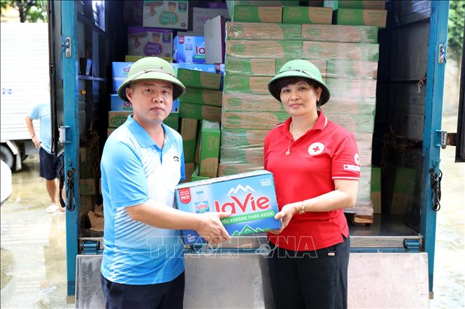 Bà Vũ Thị Quyên, Phó Chủ tịch Hội Chữ thập đỏ tỉnh Lạng Sơn trao quà cho đại diện xã Thất Khê, tỉnh Lạng Sơn để gửi tới các hộ dân bị ngập lụt trên địa bàn. Ảnh: Văn Đạt - TTXVN