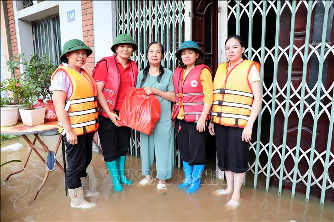 Bà Vũ Thị Quyên, Phó Chủ tịch Hội Chữ thập đỏ tỉnh Lạng Sơn trao quà cho hộ dân có nhà bị ngập tại xã Thất Khê, tỉnh Lạng Sơn. Ảnh: Văn Đạt - TTXVN