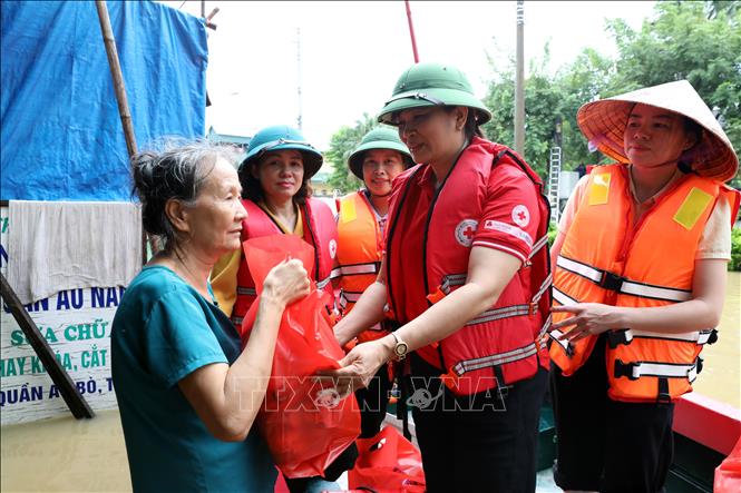 Bà Vũ Thị Quyên, Phó Chủ tịch Hội Chữ thập đỏ tỉnh Lạng Sơn trao quà cho hộ dân có nhà bị ngập tại xã Thất Khê, tỉnh Lạng Sơn. Ảnh: Văn Đạt - TTXVN