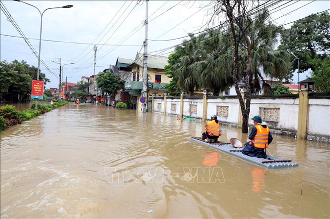 Người dân xã Thất Khê, tỉnh Lạng Sơn di chuyển bằng bè trên Quốc lộ 4A. Ảnh: Văn Đạt - TTXVN