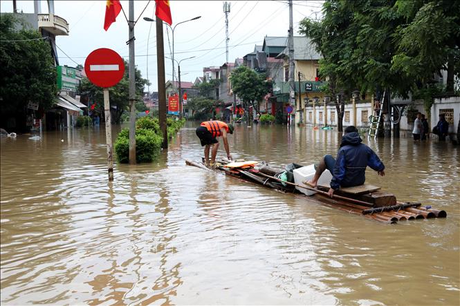 Người dân xã Thất Khê, tỉnh Lạng Sơn di chuyển bằng bè trên Quốc lộ 4A. Ảnh: Văn Đạt - TTXVN