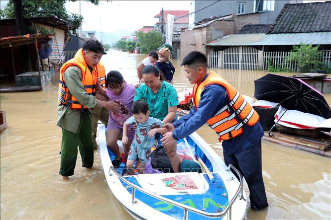 Lực lượng chức năng xã Tràng Định, tỉnh Lạng Sơn hỗ trợ đưa người dân từ vùng ngập sâu đến nơi an toàn. Ảnh: Văn Đạt - TTXVN