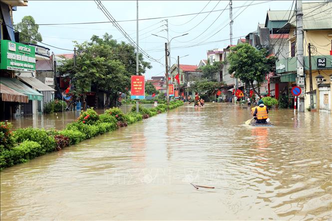 Người dân xã Thất Khê, tỉnh Lạng Sơn di chuyển bằng bè trên Quốc lộ 4A. Ảnh: Văn Đạt - TTXVN