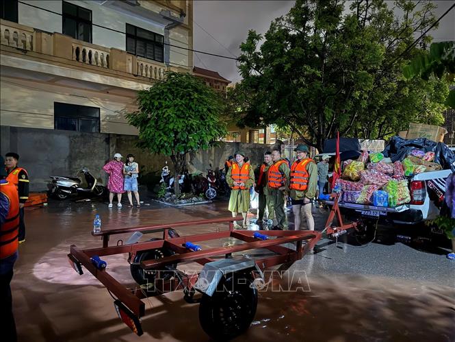 Lực lượng chức năng chuẩn bị các phương án di dời dân vùng lũ. Ảnh: Tiến Vĩnh – TTXVN 