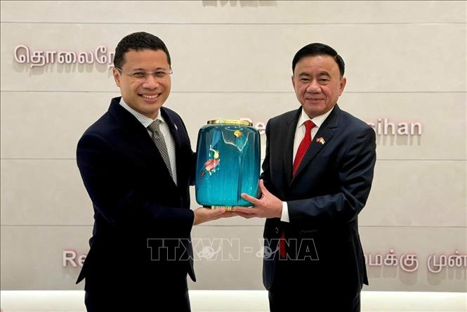 Ủy viên Bộ Chính trị, Thường trực Ban Bí thư Trần Cẩm Tú và Chủ tịch Đảng Hành động Nhân dân Singapore Desmond Lee trao tặng phẩm. Ảnh: Phương Hoa - TTXVN