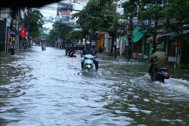 Mưa to kéo dài khiến đường Trần Hưng Đạo, phường Nam Định bị ngập, các phương tiện đi lại gặp nhiều khó khăn. Ảnh: Công Luật - TTXVN