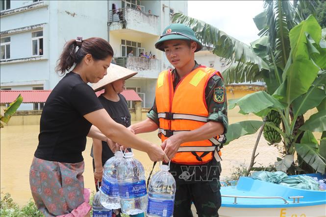 Lực lượng quân đội mang nước uống tới người dân vùng bị mưa lũ cô lập tại xã Na Sầm, tỉnh Lạng Sơn. Ảnh: Quang Duy – TTXVN
