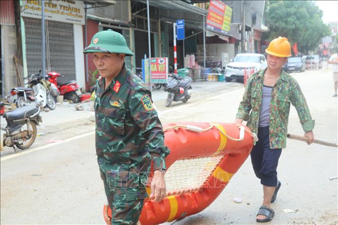 Lực lượng quân đội vận chuyển phao bè cứu sinh tới vùng ngập lụt. Ảnh: Quang Duy  - TTXVN
