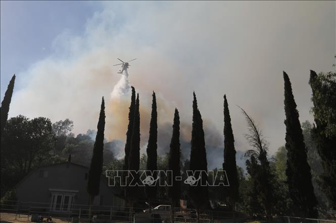 Trực thăng phun nước dập lửa cháy rừng tại California, Mỹ. Ảnh: THX/TTXVN phát