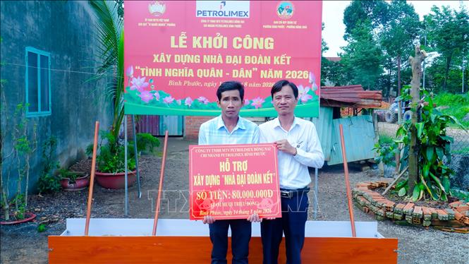 Đại diện nhà tài trợ Petrolimex trao kinh phí xây dựng cho hộ gia đình khó khăn về nhà ở. Ảnh: Nhật Bình – TTXVN