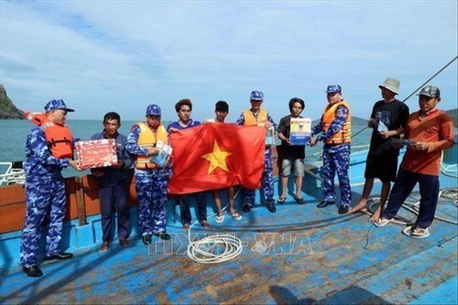 Đoàn công tác của Cảnh sát biển Việt Nam tuyên truyền, tặng cờ Tổ quốc và quà Tết cho ngư dân (1/2025). Ảnh: An Đăng - TTXVN