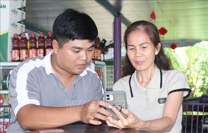 Tổ công nghệ số cộng đồng hướng dẫn hỗ trợ cài đặt các ứng dụng số cho người dân. Ảnh: Tuấn Phi - TTXVN