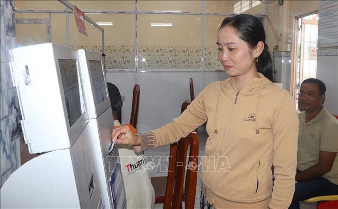 Người dân bấm số thứ tự khi đến làm thủ tục hành chính ở xã Tân Lộc. Ảnh: Tuấn Phi - TTXVN