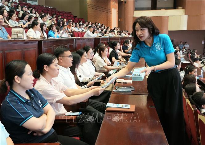 Cán bộ Bảo hiểm xã hội tỉnh Bắc Ninh phát tài liệu tuyên truyền, phổ biến chính sách bảo hiểm xã hội, bảo hiểm y tế cho đại diện các doanh nghiệp tham dự Hội nghị. Ảnh: Đồng Thúy - TTXVN
