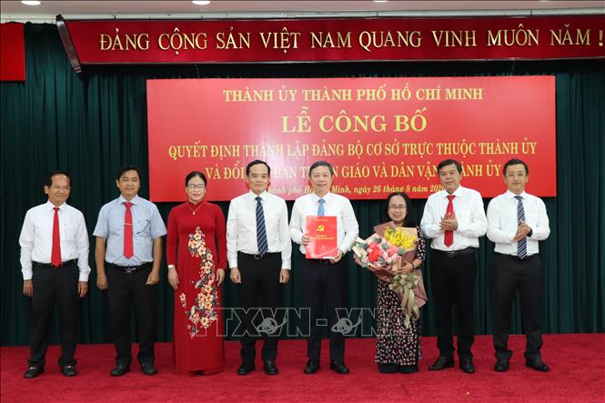 Bí thư Thành ủy Thành phố Hồ Chí Minh Trần Lưu Quang trao quyết định và hoa chúc mừng lãnh đạo Ban Tuyên giáo Thành ủy TP. Hồ Chí Minh. Ảnh: TTXVN phát