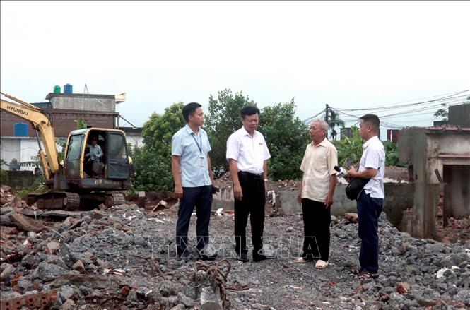Ông Phạm Văn Tá (thứ hai từ phải sang) đã chủ động tháo dỡ công trình của gia đình để bàn giao mặt bằng sạch phục vụ thi công tuyến đường số 3 thuốc dự án đường trục kết nối Khu kinh tế Thái Bình, tỉnh Hưng Yên. Ảnh: Đinh Văn Nhiều - TTXVN