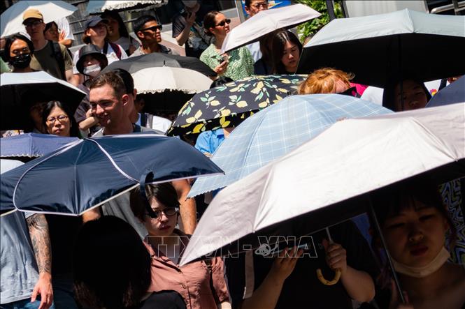 Người dân che ô tránh nắng nóng tại Tokyo, Nhật Bản. Ảnh: THX/TTXVN phát