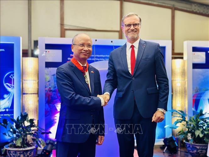 Thừa ủy quyền của Tổng thống Cộng hòa Pháp, Đại sứ Pháp tại Việt Nam Olivier Brochet trân trọng trao Huân chương Bắc đẩu Bội tinh tặng Đại sứ Đinh Toàn Thắng. Ảnh: Việt Đức - TTXVN.