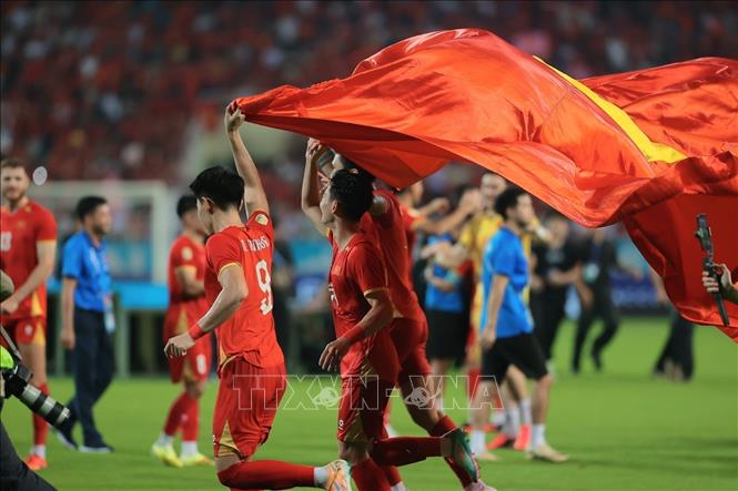 Các tuyển thủ Việt Nam giương cao lá quốc kỳ chạy quanh sân sau khi trận đấu kết thúc, khép lại hành trình hoàn hảo bảo vệ ngôi vô địch. Ảnh: Minh Quyết - TTXVN