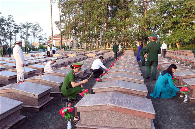 Các đại biểu cùng lực lượng vũ trang thắp hương tại các khu mộ trong nghĩa trang. Ảnh: Trung Kiên - TTXVN