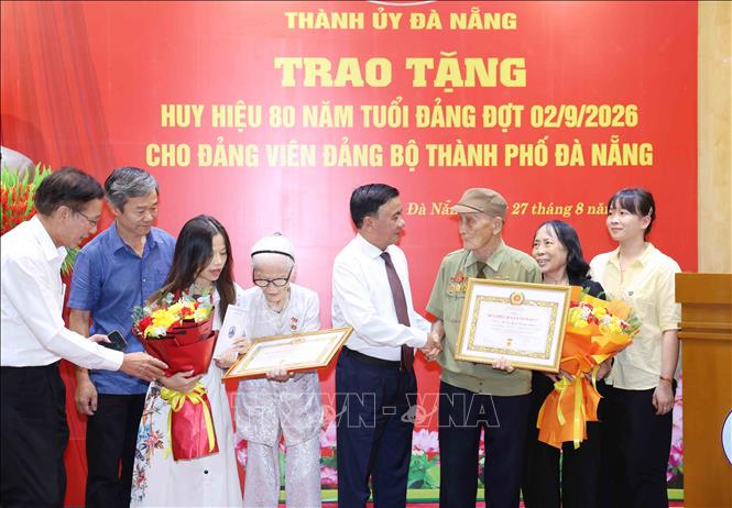 Thường trực Ban Bí thư Trần Cẩm Tú cùng gia đình 2 đảng viên lão thành Nguyễn Thị Hữu và Hồ Văn Lang, Đảng bộ thành phố Đà Nẵng. Ảnh: Phương Hoa - TTXVN