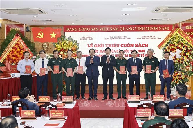 Chủ tịch Quốc hội Trần Thanh Mẫn và Đại tướng Lương Cường, nguyên Ủy viên Bộ Chính trị, nguyên Chủ tịch nước trao tặng sách cho đại biểu. Ảnh: Doãn Tấn - TTXVN