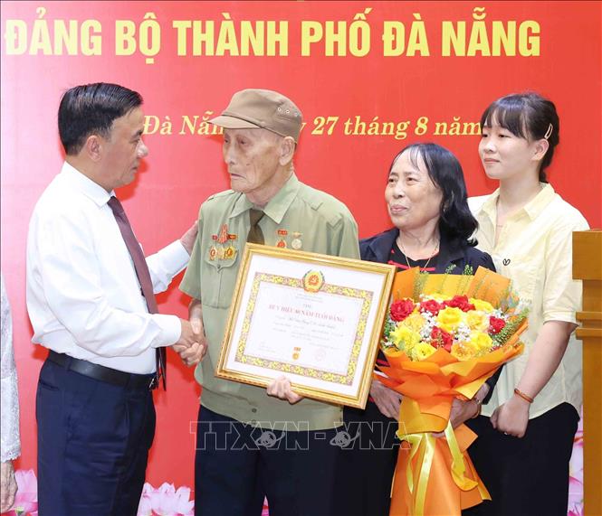 Thường trực Ban Bí thư Trần Cẩm Tú cùng gia đình đảng viên lão thành Hồ Văn Lang. Ảnh: Phương Hoa - TTXVN