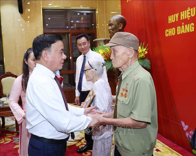 Thường trực Ban Bí thư Trần Cẩm Tú trao Huy hiệu 80 năm tuổi Đảng cho đảng viên lão thành Hồ Văn Lang. Ảnh: Phương Hoa - TTXVN