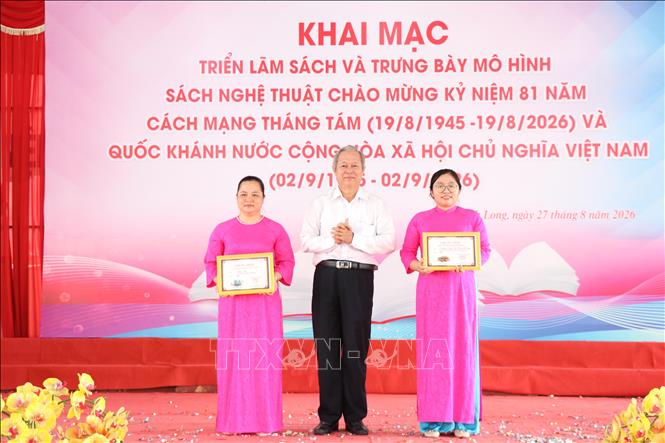 Ban Tổ chức trao giải Nhì Cuộc thi Xếp sách nghệ thuật tại lễ khai mạc triển lãm. Ảnh: Thanh Hòa - TTXVN