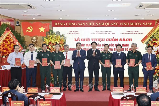 Chủ tịch Quốc hội Trần Thanh Mẫn và Đại tướng Lương Cường, nguyên Ủy viên Bộ Chính trị, nguyên Chủ tịch nước trao tặng sách cho đại biểu. Ảnh: Doãn Tấn - TTXVN