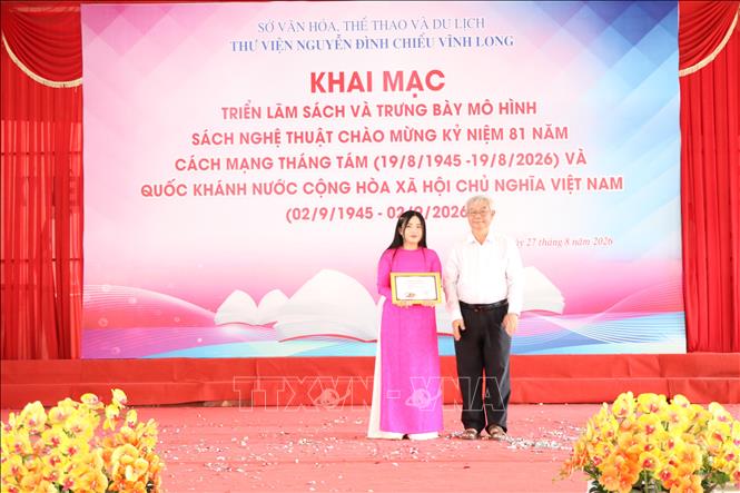 Ban Tổ chức trao giải Nhất Cuộc thi Xếp sách nghệ thuật tại lễ khai mạc triển lãm. Ảnh: Thanh Hòa - TTXVN