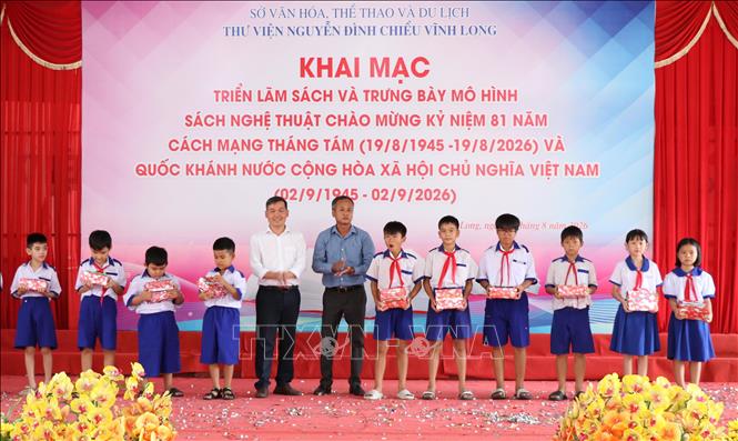 Ban Tổ chức trao quà cho học sinh vượt khó học giỏi tại lễ khai mạc triển lãm. Ảnh: Thanh Hòa - TTXVN